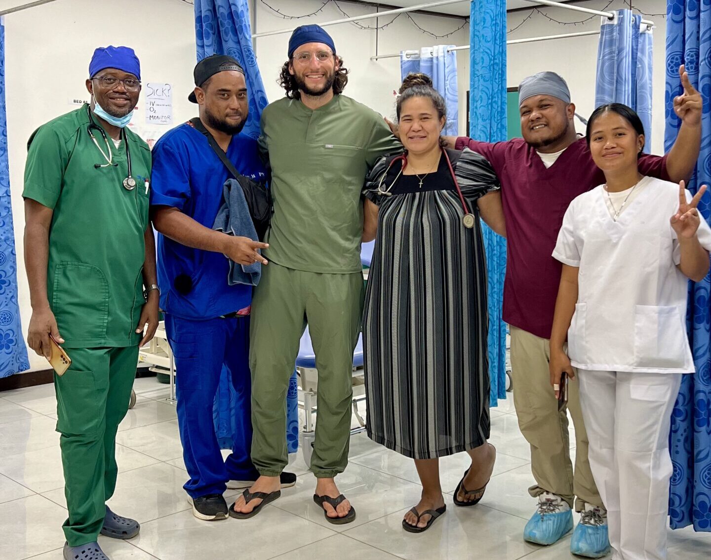 a group of people standing in a hospital room